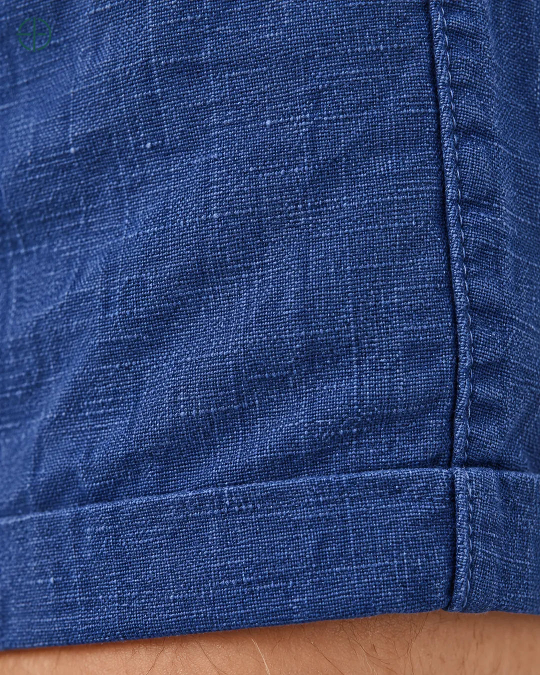 Bermuda 100% Linho Belga Masculina, cor Azul, Detalhe do tecido e da barra no modelo, em estúdio profissional com fundo cinza ostra.