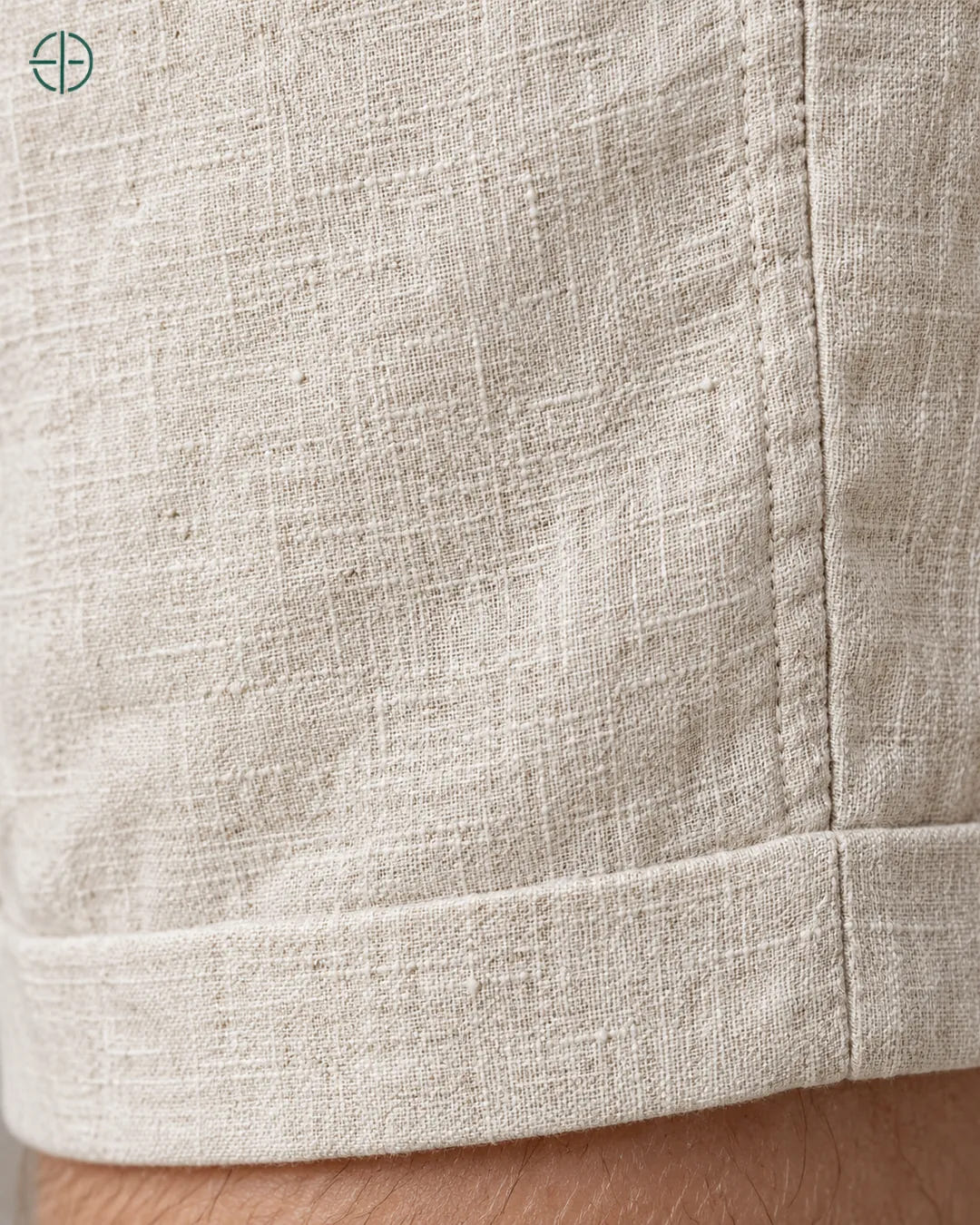 Bermuda 100% Linho Belga Masculina, cor Bege, Detalhe do tecido e da barra no modelo, em estúdio profissional com fundo cinza ostra.