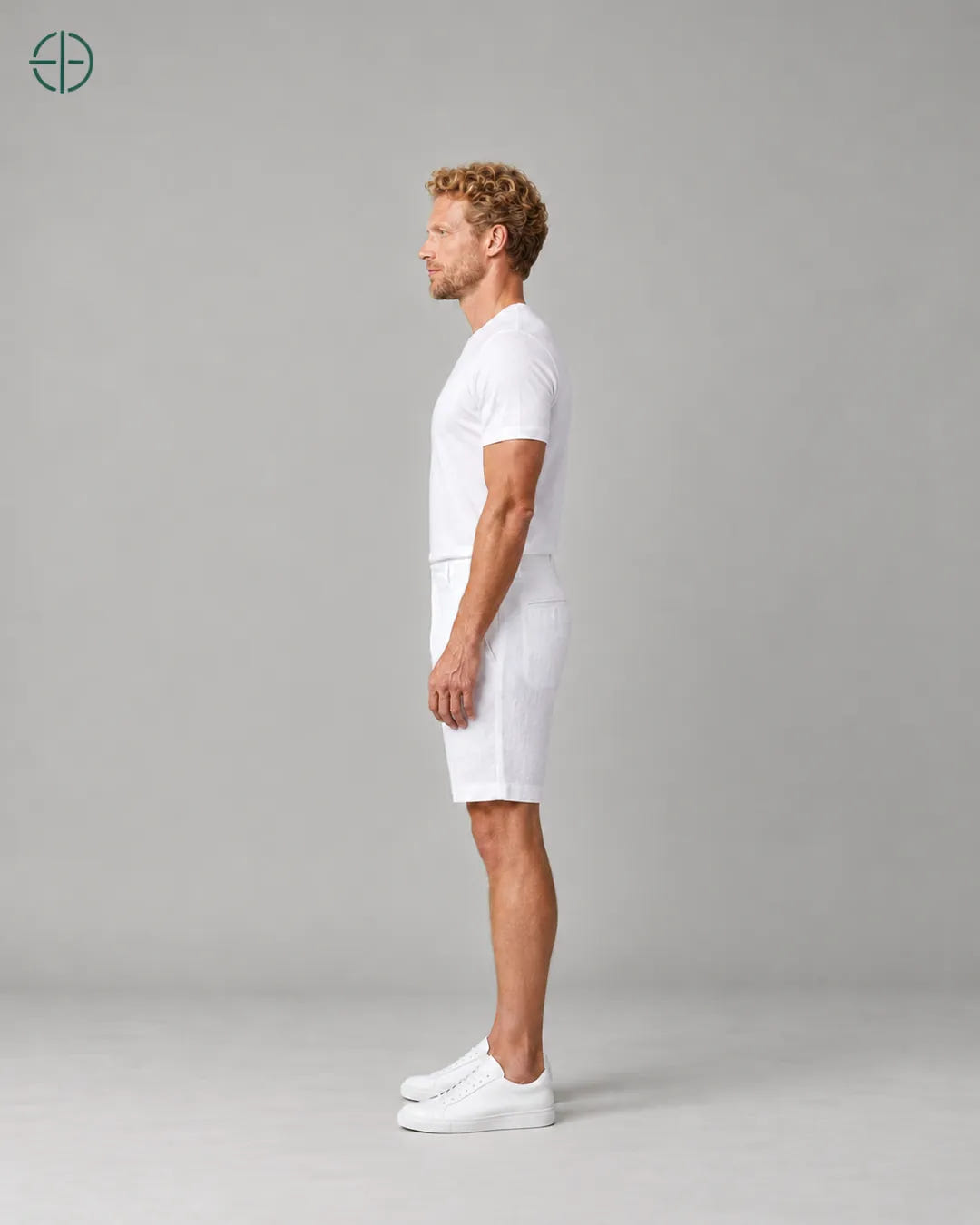 Bermuda 100% Linho Belga Masculina, cor Branco, Mesmo modelo e roupa de lado, em estúdio profissional com fundo cinza ostra.