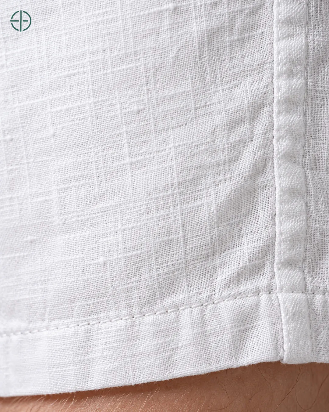 Bermuda 100% Linho Belga Masculina, cor Branco, Detalhe do tecido e da barra no modelo, em estúdio profissional com fundo cinza ostra.