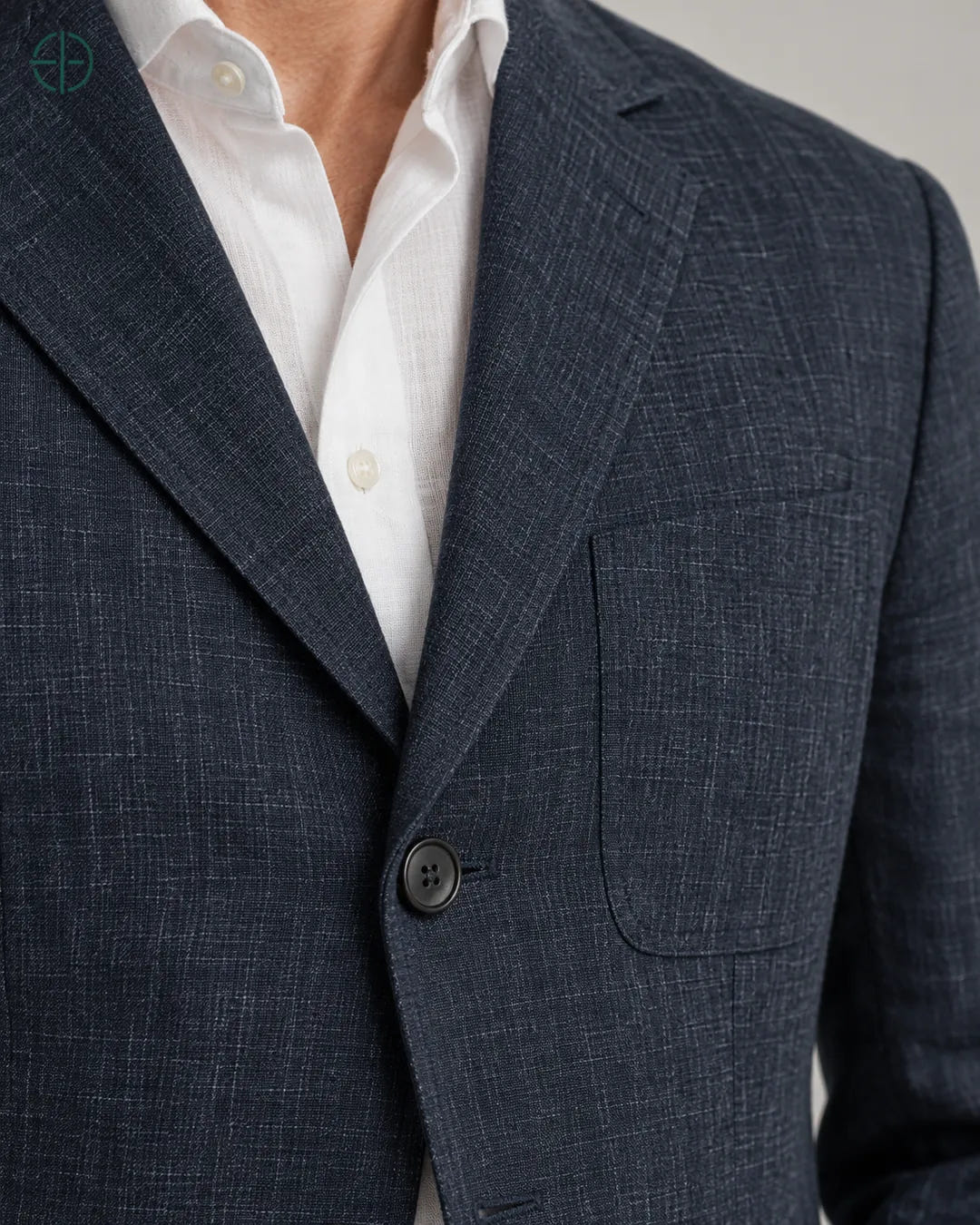 Blazer 100% Linho Belga, cor Azul Marinho, macro do produto no modelo, em estúdio profissional com fundo cinza ostra.