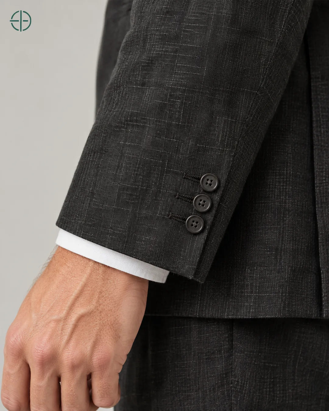 Blazer 100% Linho Belga, cor Preto, Detalhe aproximado do tecido e da costura no modelo, mostrando textura real, em estúdio profissional com fundo cinza ostra.