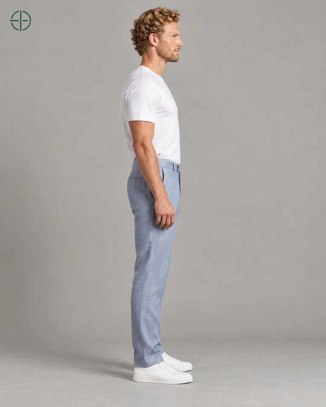 Calça 100% Linho Belga Masculina, cor Azul Claro, mesmo modelo e roupa de lado, em estúdio profissional com fundo cinza ostra.