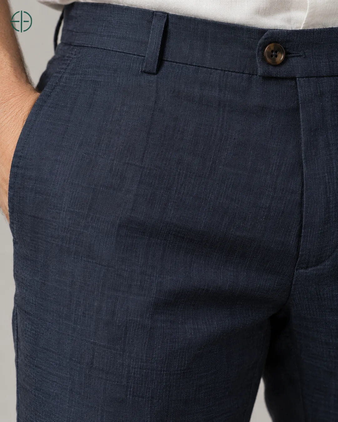 Calça 100% Linho Belga Masculina, cor Azul Marinho, macro do produto no modelo, em estúdio profissional com fundo cinza ostra.