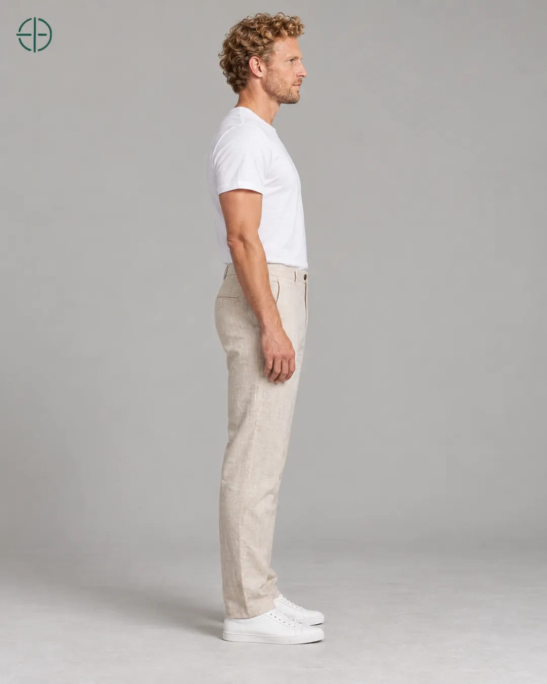 Calça 100% Linho Belga Masculina, cor Bege, mesmo modelo e roupa de lado, em estúdio profissional com fundo cinza ostra.