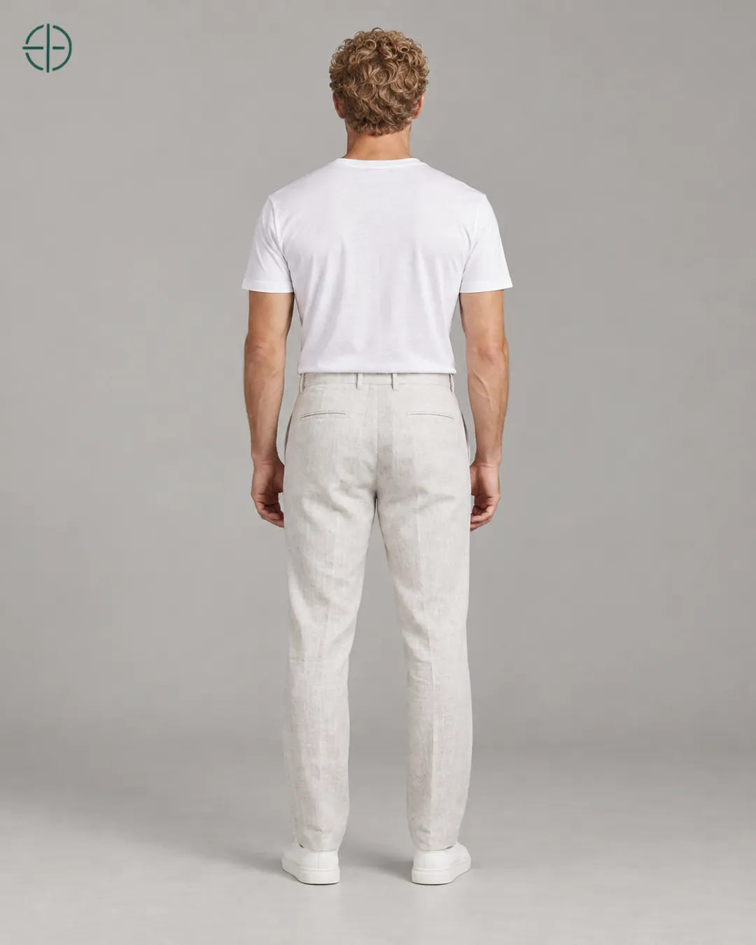 Calça 100% Linho Belga Masculina, cor Branco, mesmo modelo e roupa de costas, em estúdio profissional com fundo cinza ostra.