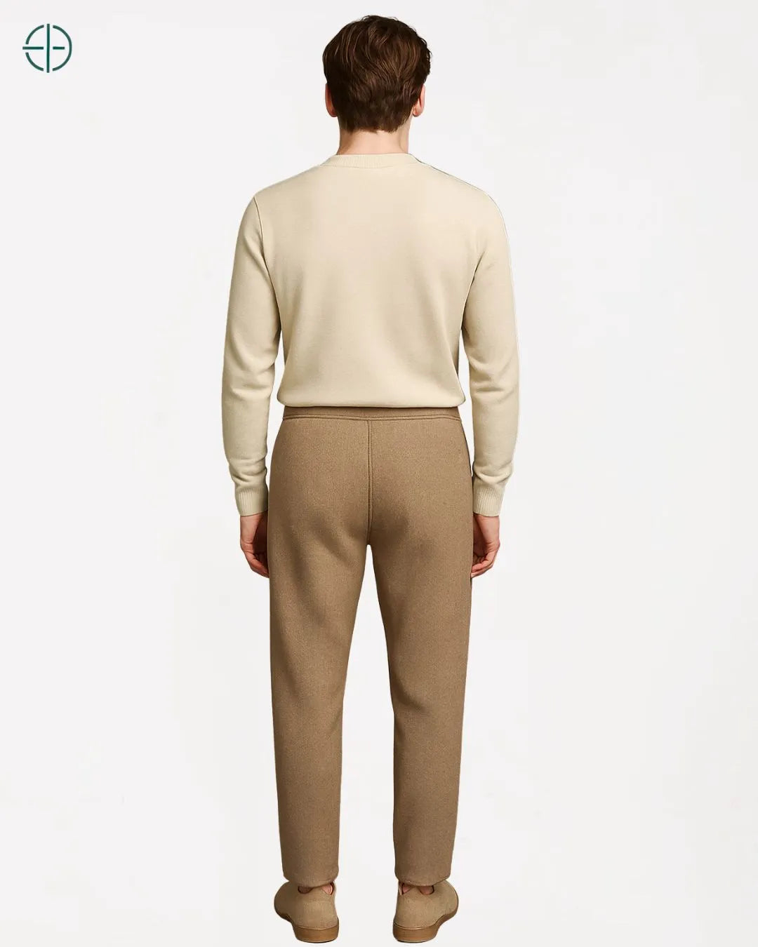 Modelo vestindo calça de caxemira bege em vista de perfil para mostrar o corte da perna.