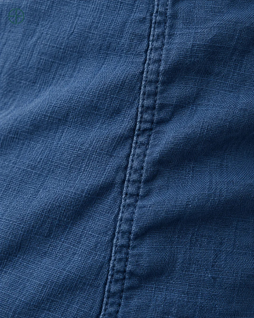 Camisa 100% Linho Belga Manga Curta, cor Azul Marinho, macro do produto no modelo, em estúdio profissional com fundo cinza ostra.