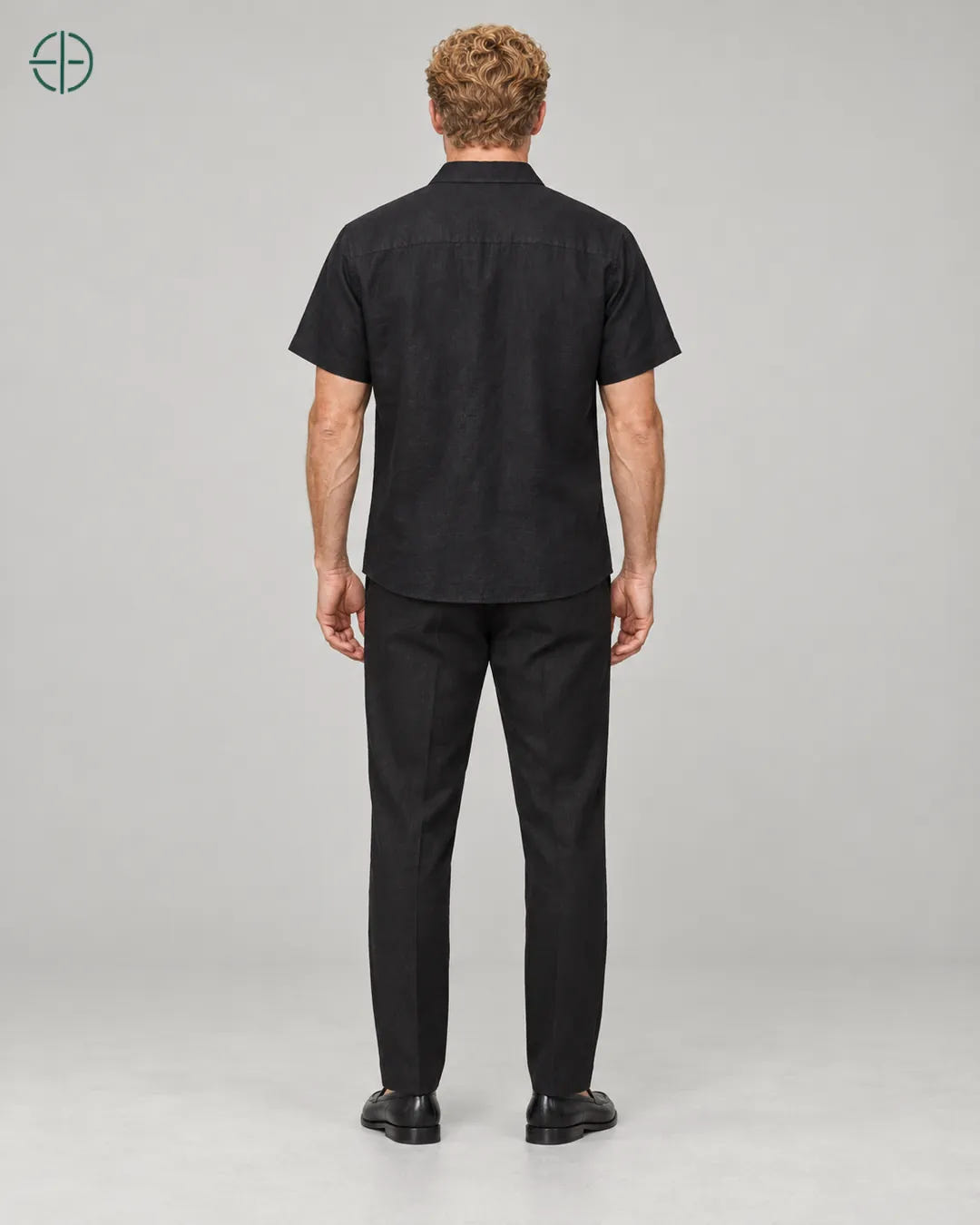 Camisa 100% Linho Belga Manga Curta, cor Preto, mesmo modelo e roupa de costas, em estúdio profissional com fundo cinza ostra.