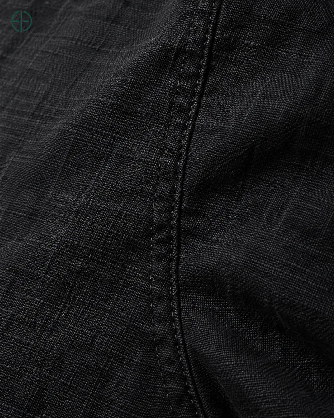 Camisa 100% Linho Belga Manga Curta, cor Preto, macro do produto no modelo, em estúdio profissional com fundo cinza ostra.