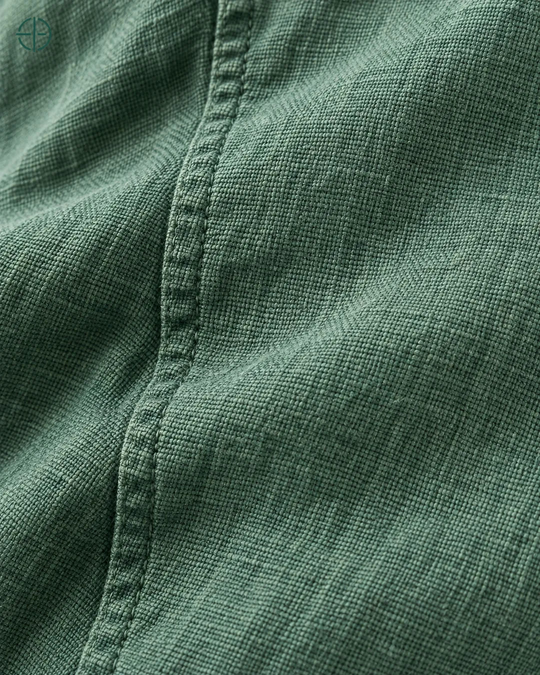 Camisa 100% Linho Belga Manga Curta, cor Verde, macro do produto no modelo, em estúdio profissional com fundo cinza ostra.