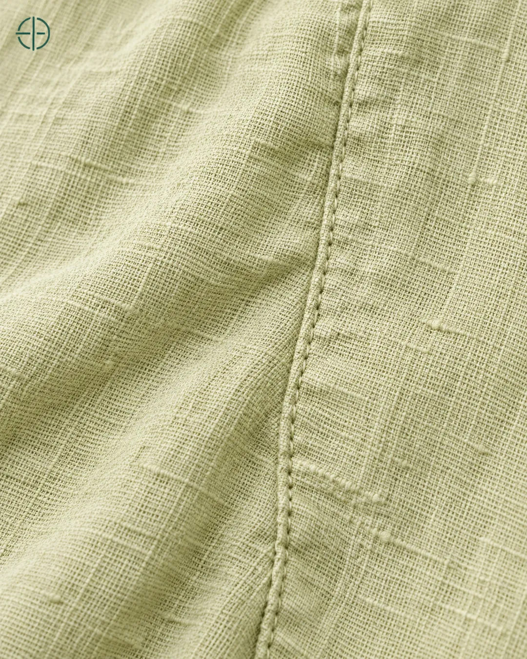Camisa 100% Linho Belga Manga Curta, cor Verde Limão, macro do produto no modelo, em estúdio profissional com fundo cinza ostra.