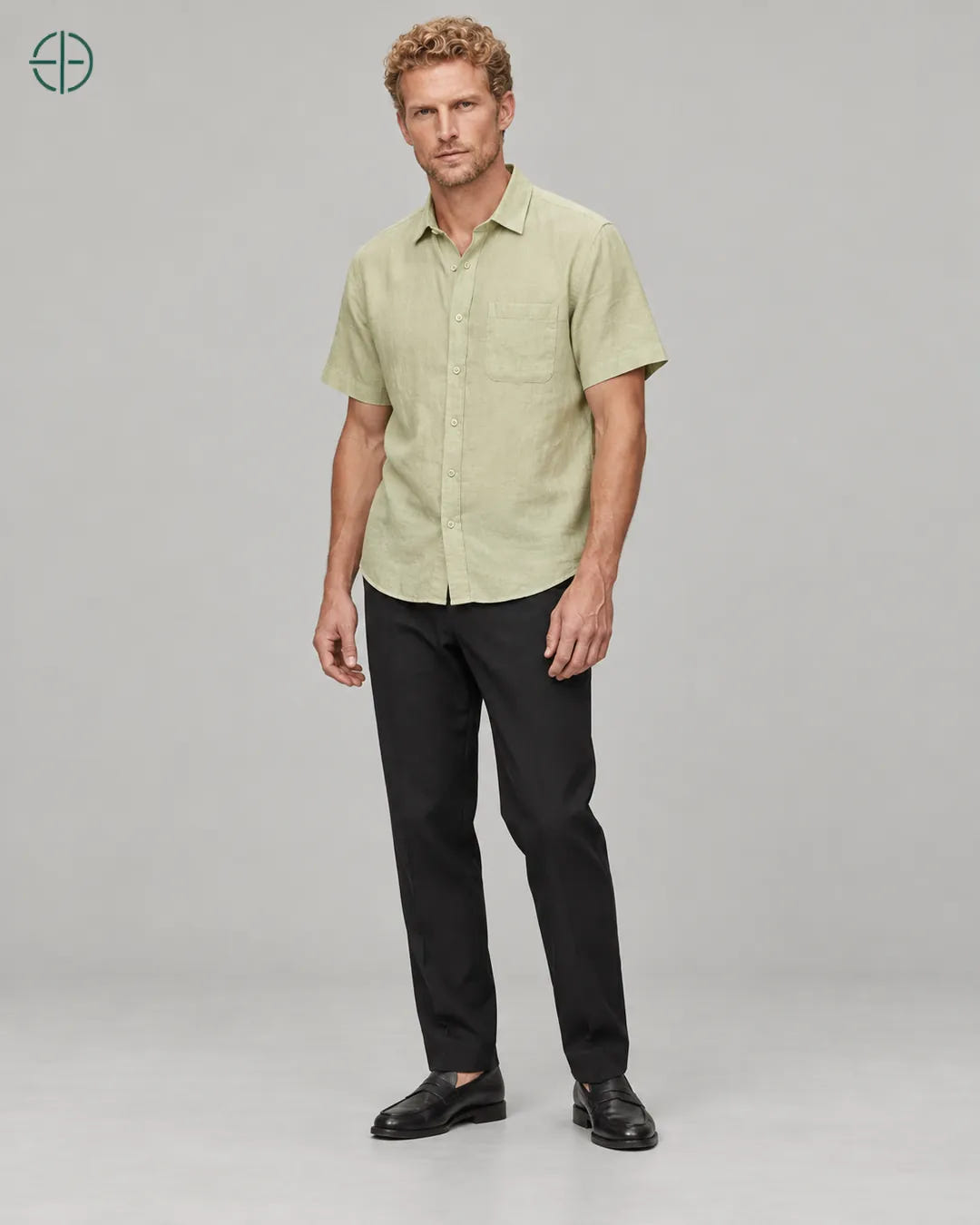 Camisa 100% Linho Belga Manga Curta, cor Verde Limão, Mesmo modelo e roupa em pose natural de três quartos, mostrando o caimento da peça, em estúdio profissional com fundo cinza ostra.