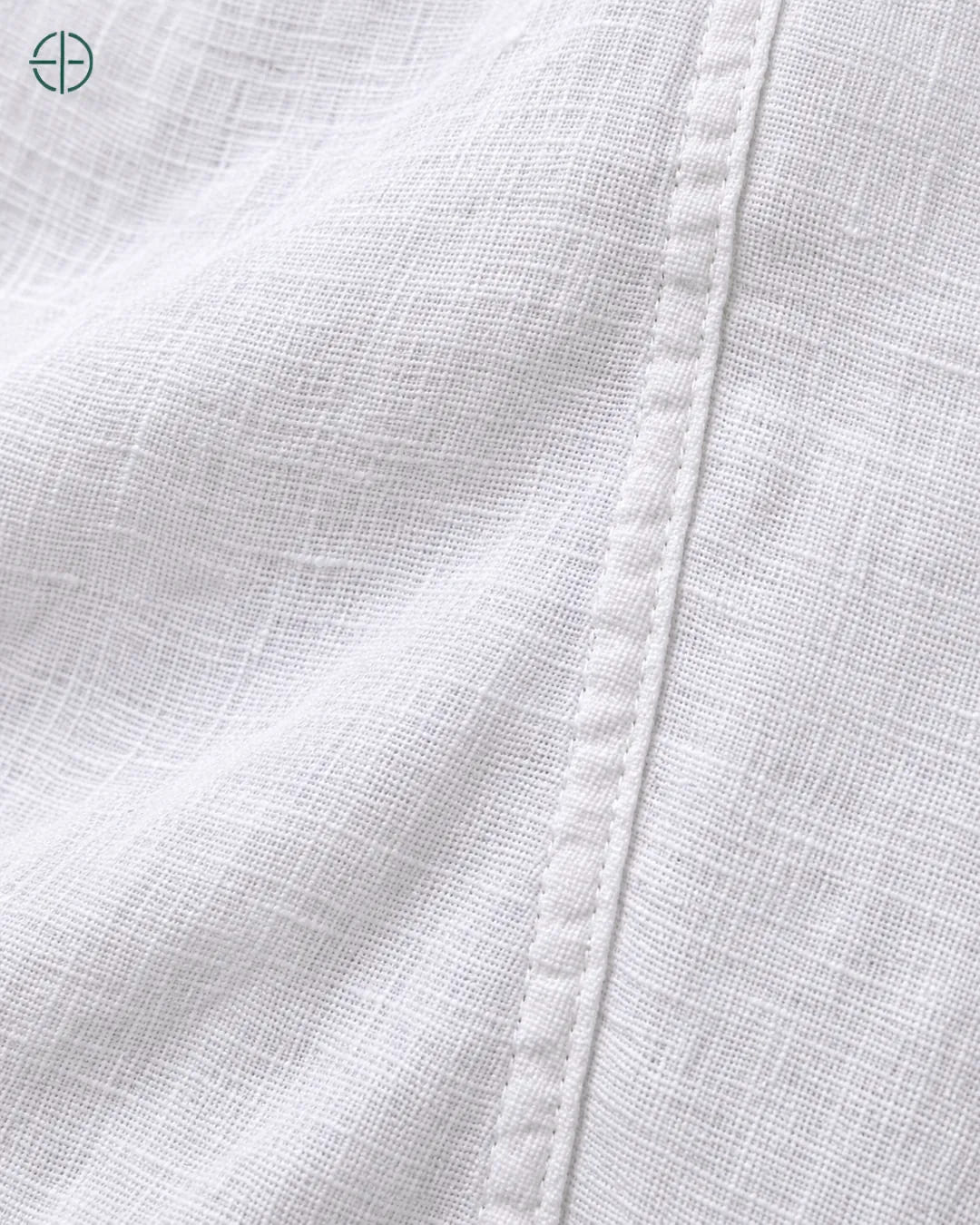 Camisa 100% Linho Belga Masculina, cor Branco, macro do produto no modelo, em estúdio profissional com fundo cinza ostra.