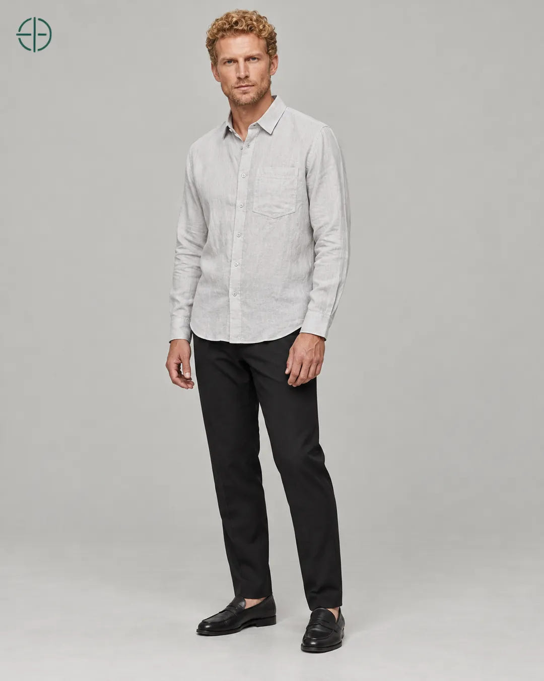 Camisa 100% Linho Belga Masculina, cor Cinza, Mesmo modelo e roupa em pose natural de três quartos, mostrando o caimento da peça, em estúdio profissional com fundo cinza ostra.