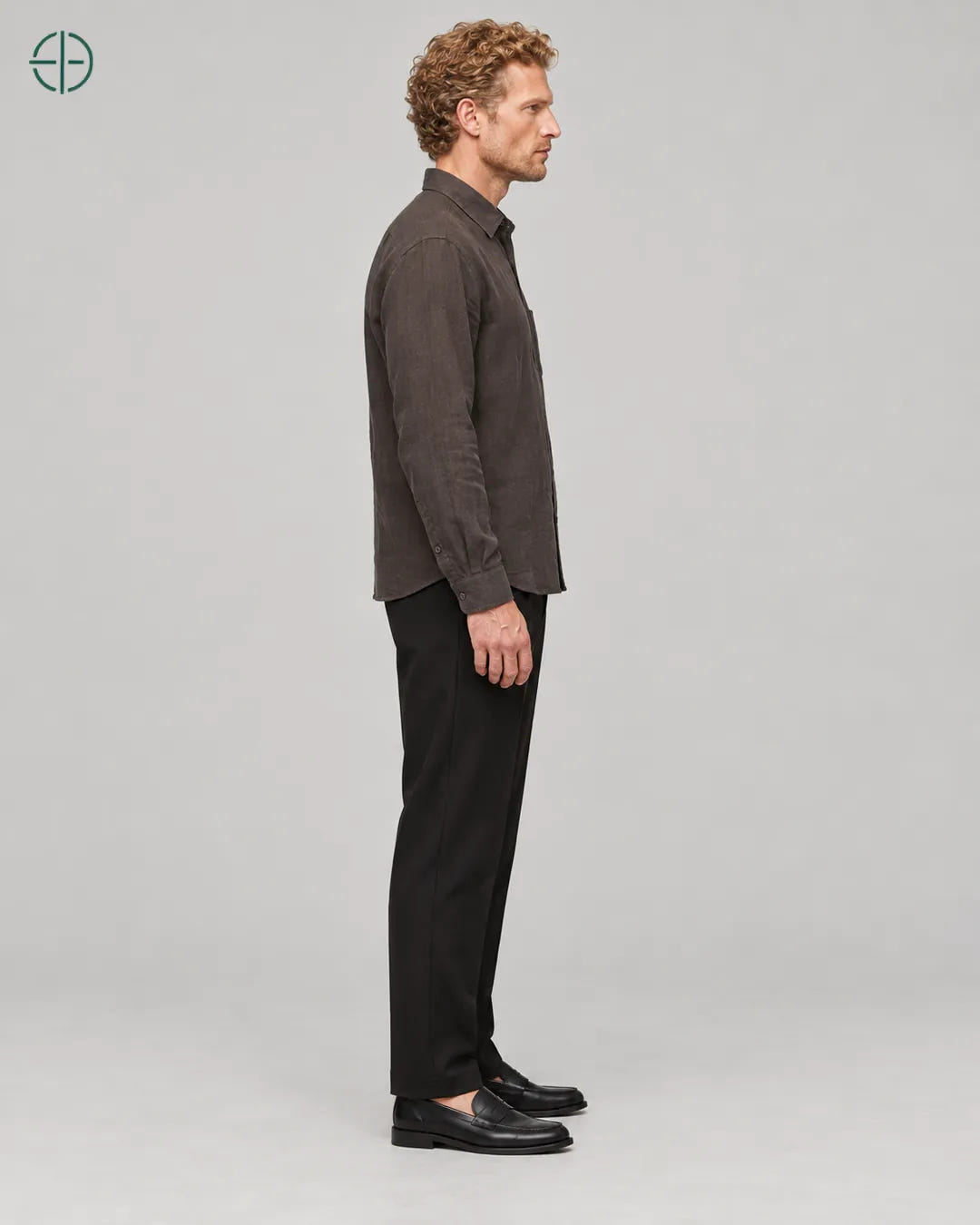 Camisa 100% Linho Belga Masculina, cor Marrom, mesmo modelo e roupa de lado, em estúdio profissional com fundo cinza ostra.