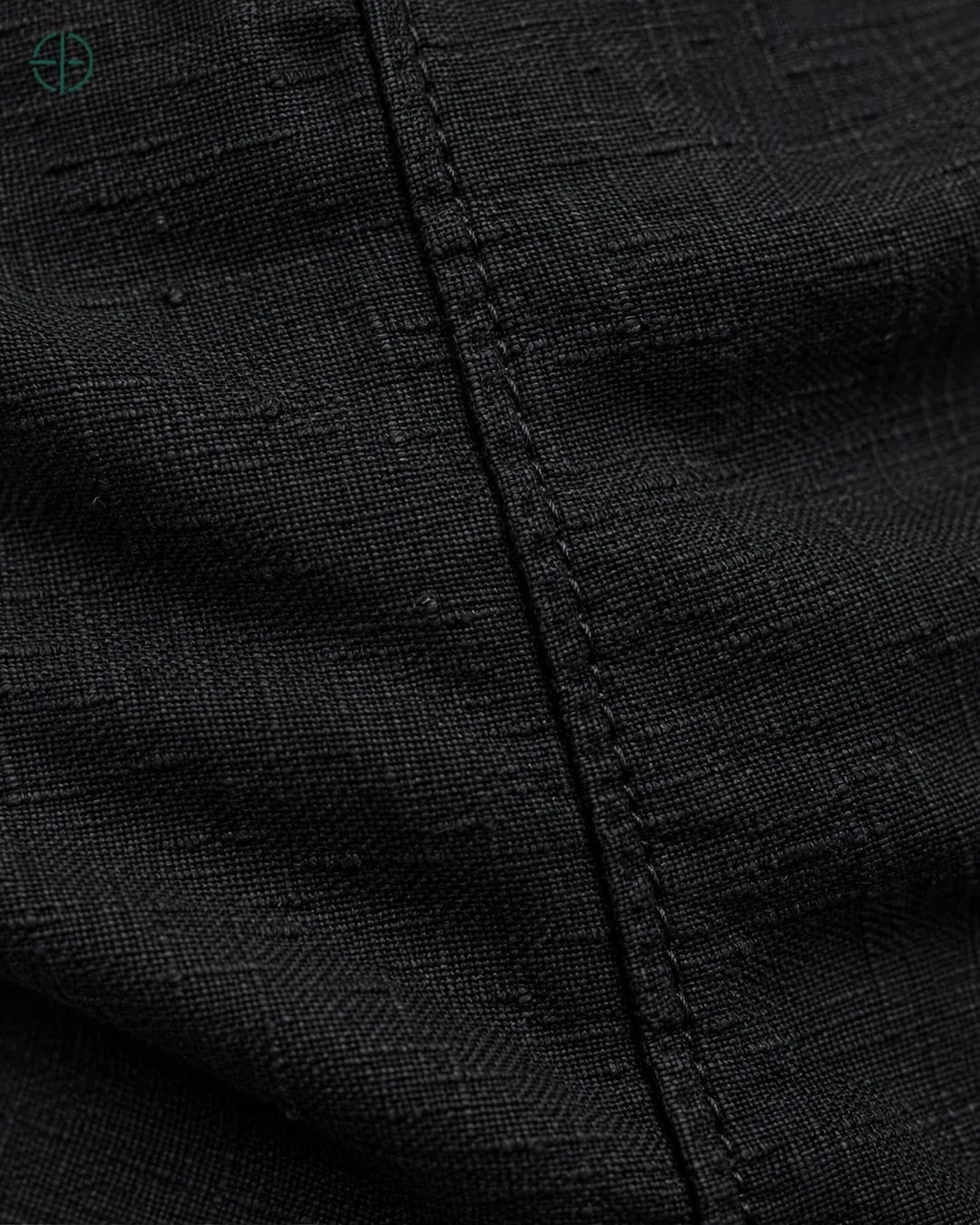 Camisa 100% Linho Belga Masculina, cor Preto, macro do produto no modelo, em estúdio profissional com fundo cinza ostra.
