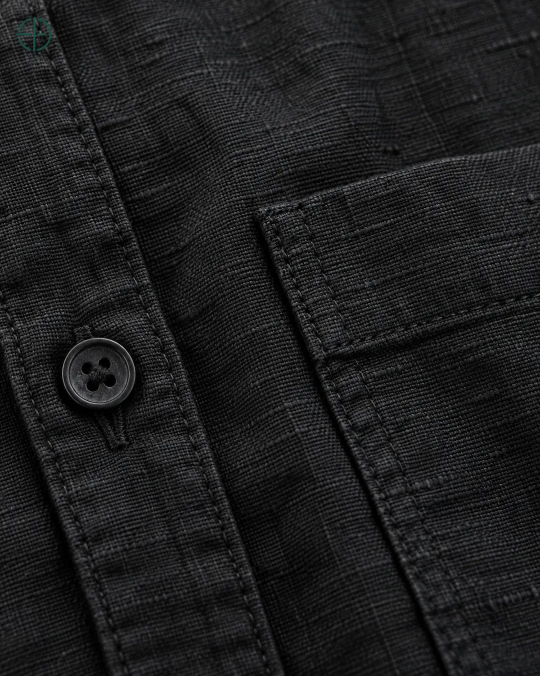 Camisa 100% Linho Belga Masculina, cor Preto, Detalhe aproximado do tecido e da costura no modelo, mostrando textura real, em estúdio profissional com fundo cinza ostra.