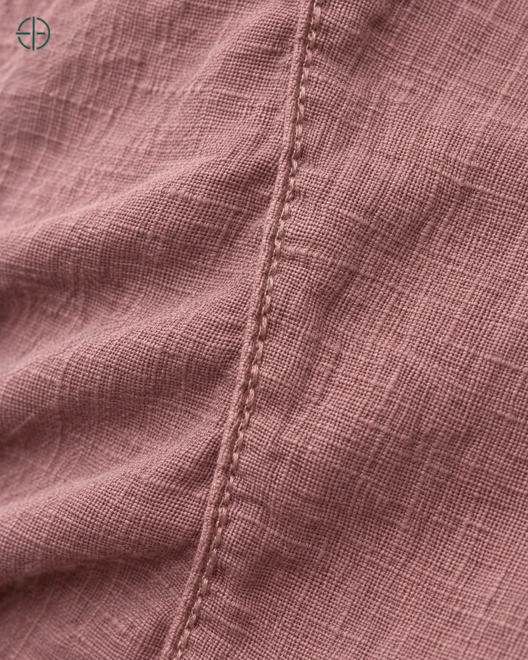 Camisa 100% Linho Belga Masculina, cor Rosa, macro do produto no modelo, em estúdio profissional com fundo cinza ostra.