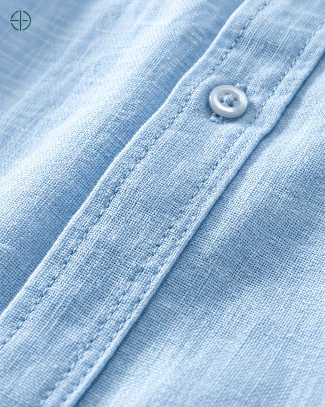 Camisa 100% Linho Belga Masculina Sem Bolso, cor Azul Claro, Detalhe aproximado do tecido e da costura no modelo, mostrando textura real, em estúdio profissional com fundo cinza ostra.