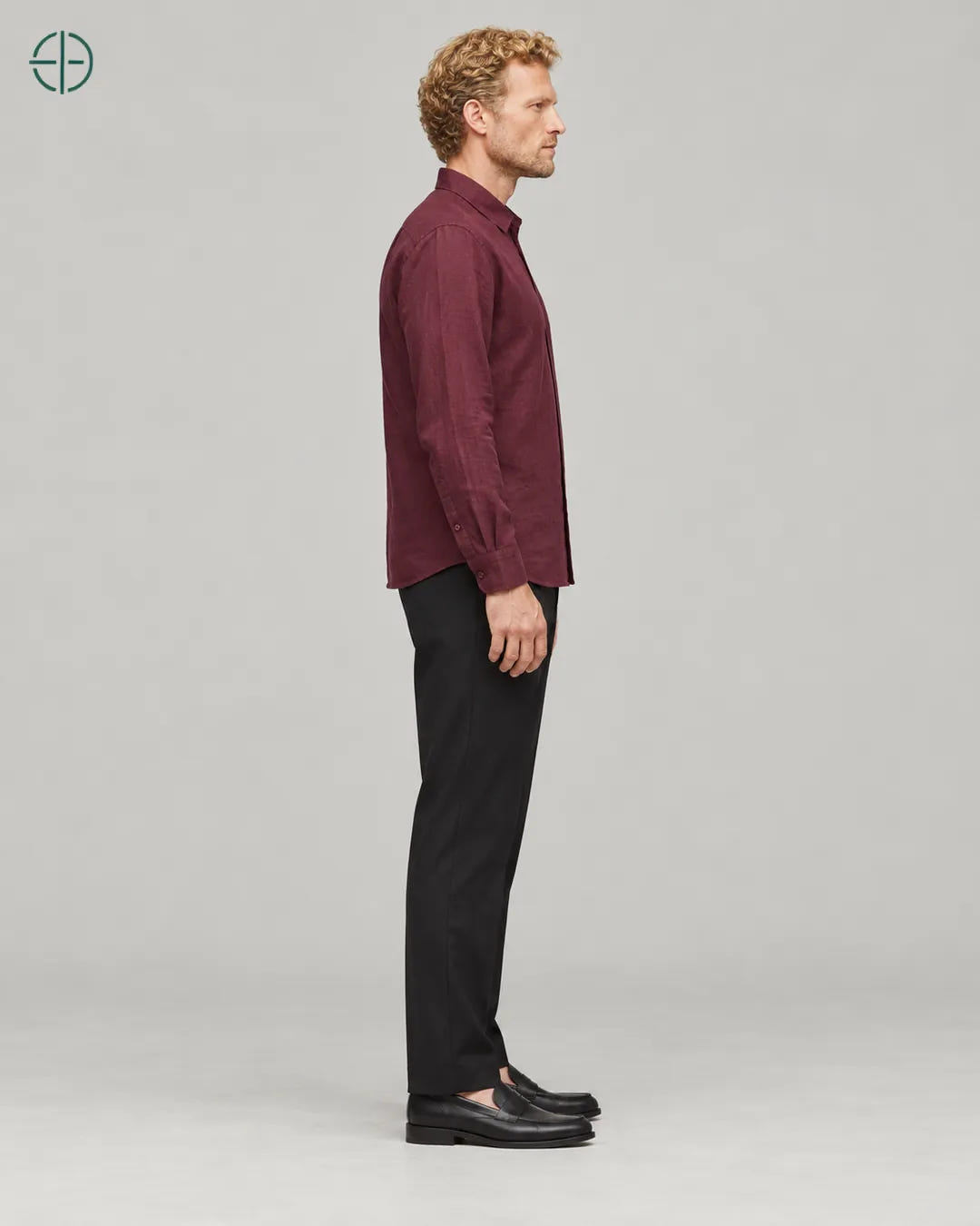 Camisa 100% Linho Belga Masculina Sem Bolso, cor Bordo, mesmo modelo e roupa de lado, em estúdio profissional com fundo cinza ostra.