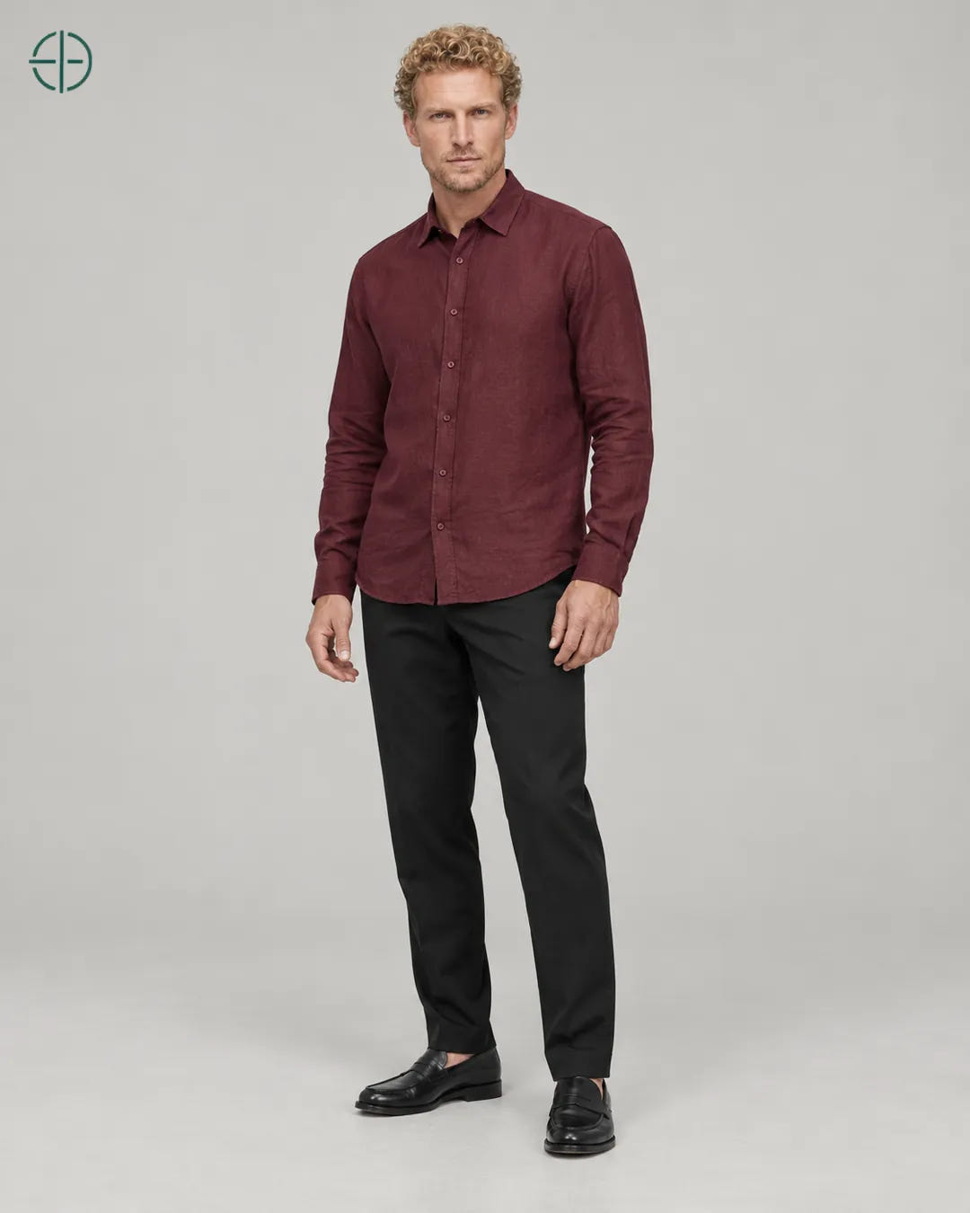 Camisa 100% Linho Belga Masculina Sem Bolso, cor Bordo, Mesmo modelo e roupa em pose natural de três quartos, mostrando o caimento da peça, em estúdio profissional com fundo cinza ostra.