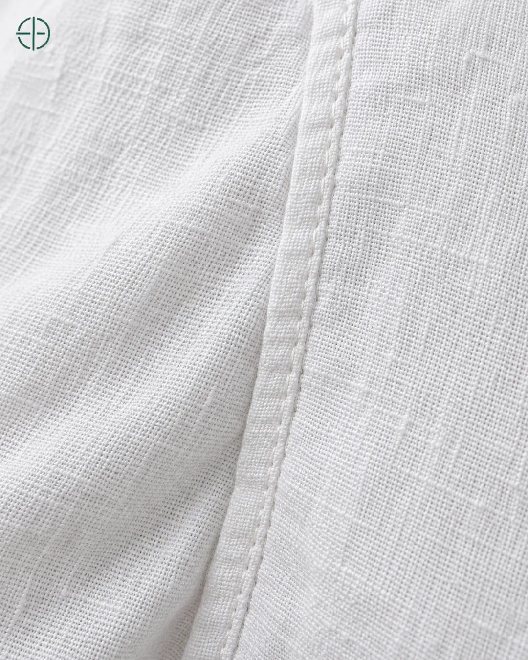 Camisa 100% Linho Belga Masculina Sem Bolso, cor Branco, macro do produto no modelo, em estúdio profissional com fundo cinza ostra.