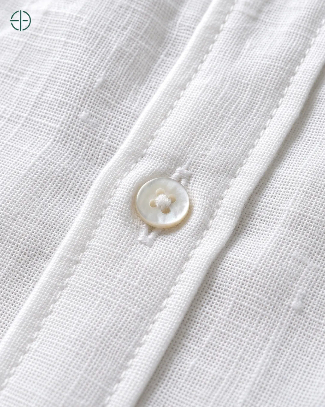 Camisa 100% Linho Belga Masculina Sem Bolso, cor Branco, Detalhe aproximado do tecido e da costura no modelo, mostrando textura real, em estúdio profissional com fundo cinza ostra.
