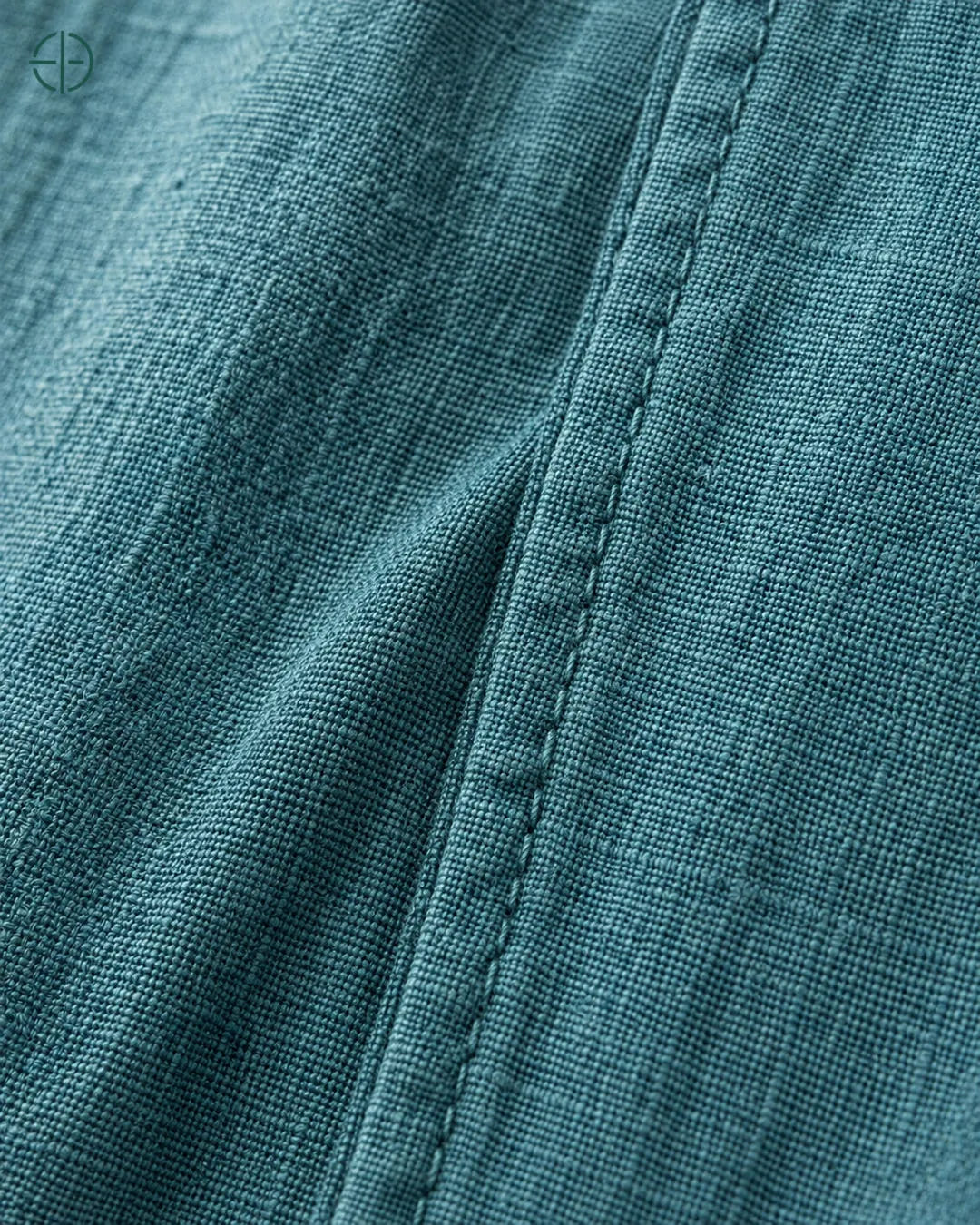 Camisa 100% Linho Belga Masculina Sem Bolso, cor Ciano, macro do produto no modelo, em estúdio profissional com fundo cinza ostra.