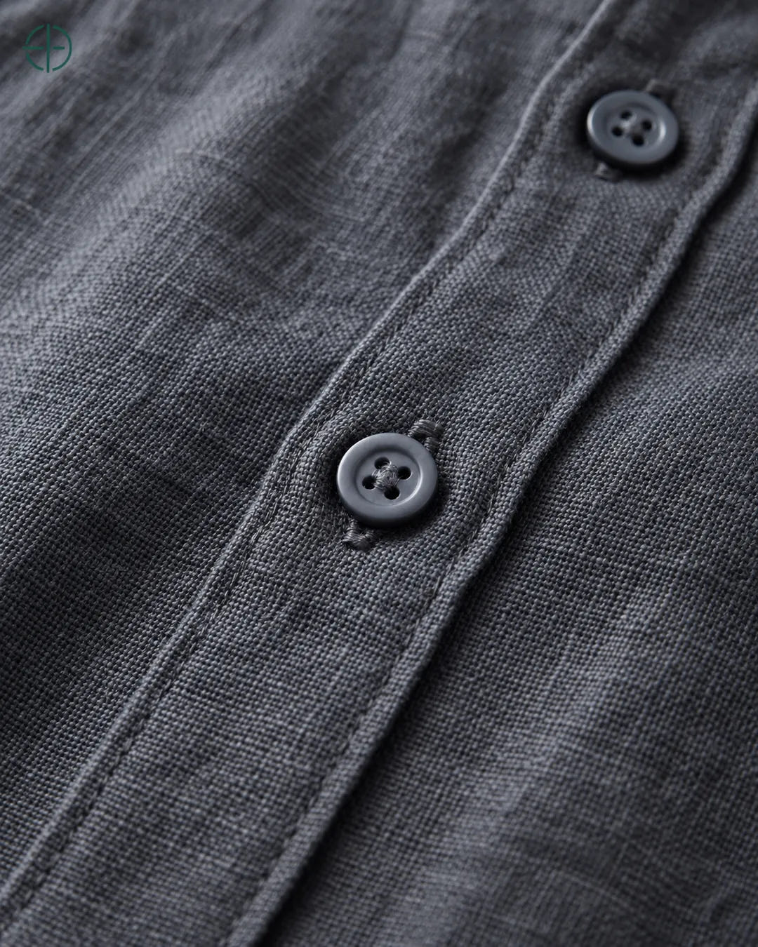 Camisa 100% Linho Belga Masculina Sem Bolso, cor Grisalho, Detalhe aproximado do tecido e da costura no modelo, mostrando textura real, em estúdio profissional com fundo cinza ostra.