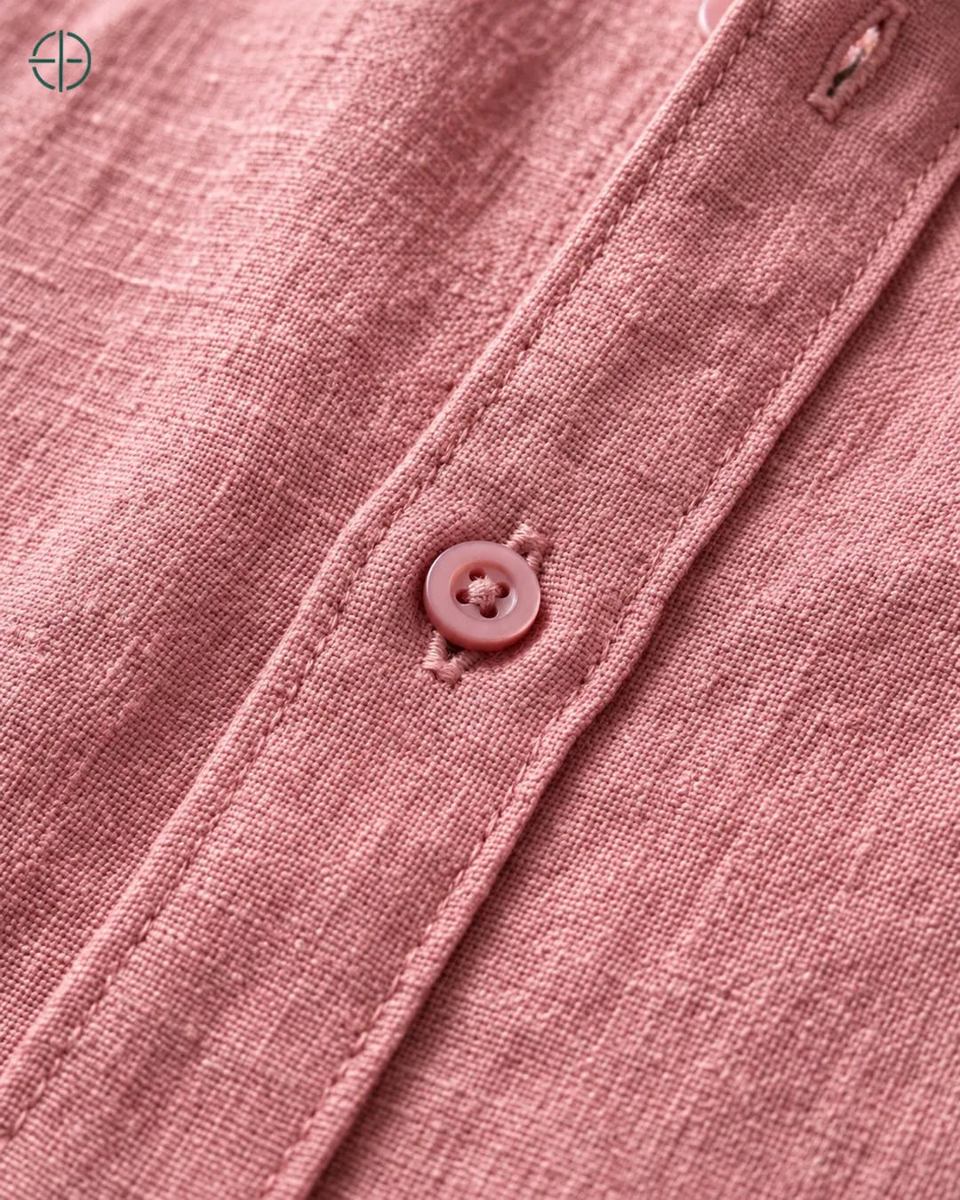 Camisa 100% Linho Belga Masculina Sem Bolso, cor Rosa, Detalhe aproximado do tecido e da costura no modelo, mostrando textura real, em estúdio profissional com fundo cinza ostra.