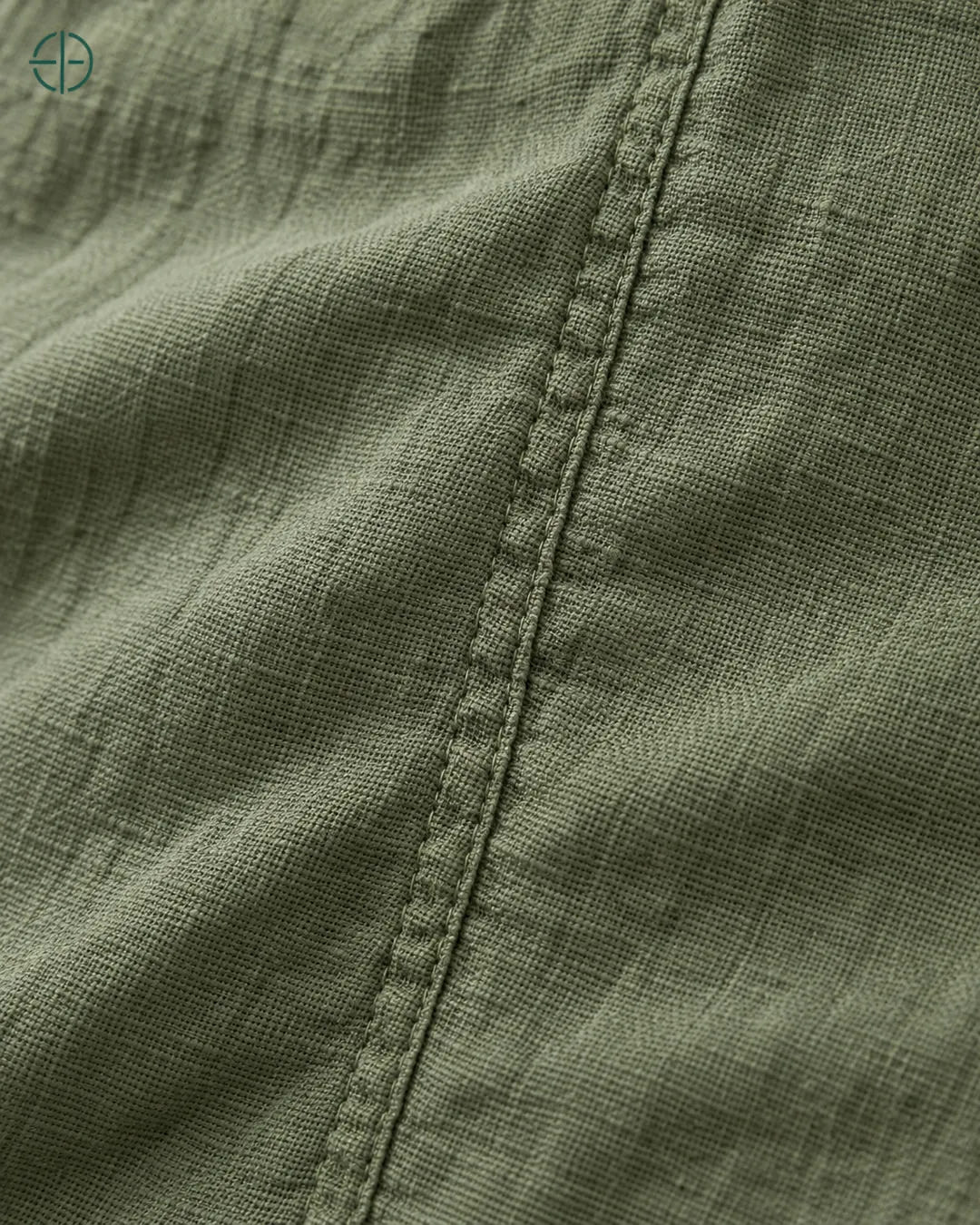 Camisa 100% Linho Belga Masculina, cor Verde, macro do produto no modelo, em estúdio profissional com fundo cinza ostra.