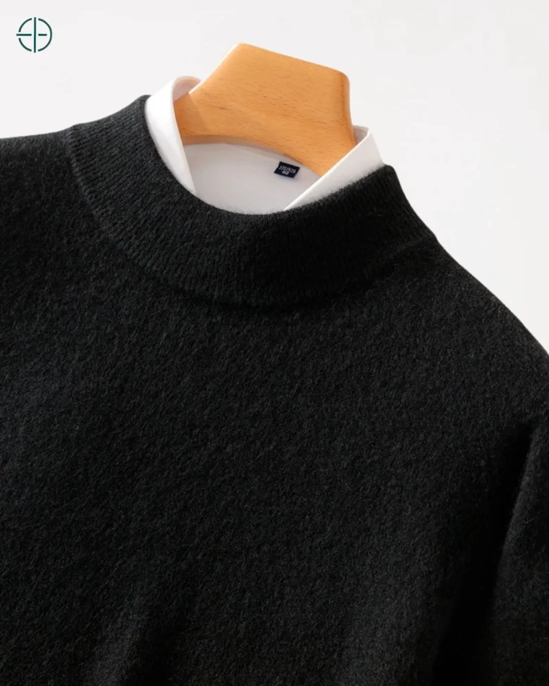 Suéter de caxemira pendurado em cabide de luxo para mostrar seu caimento vertical.