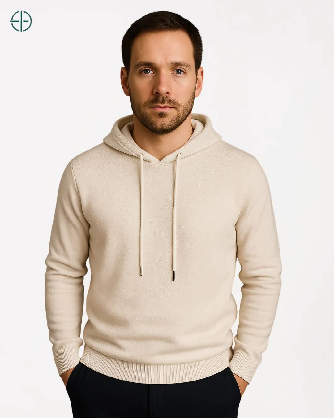 Look de inverno masculino com suéter de capuz, calça de alfaiataria e botas.