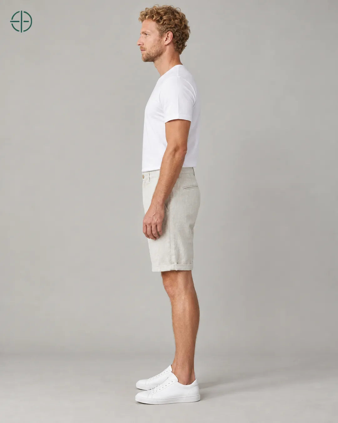 Bermuda 100% Linho Belga Masculina, cor Bege, Mesmo modelo e roupa de lado, em estúdio profissional com fundo cinza ostra.