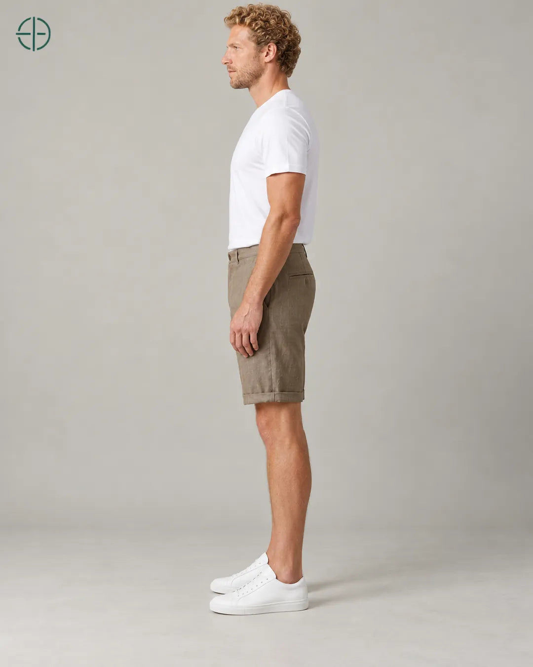 Bermuda 100% Linho Belga Masculina, cor Marrom, Mesmo modelo e roupa de lado, em estúdio profissional com fundo cinza ostra.