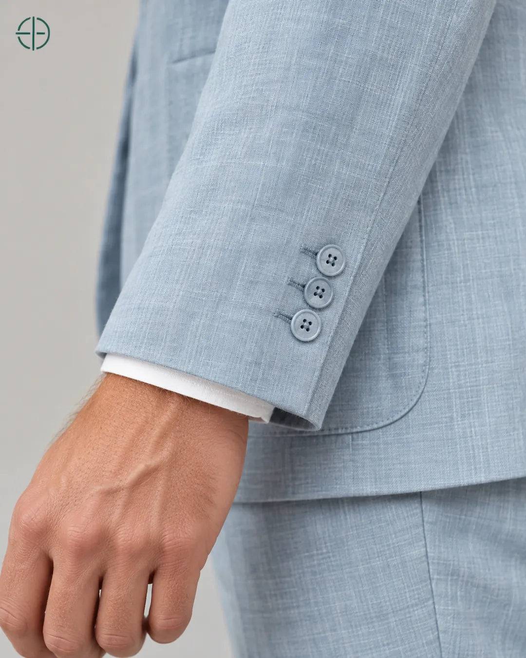 Blazer 100% Linho Belga, cor Azul, Detalhe aproximado do tecido e da costura no modelo, mostrando textura real, em estúdio profissional com fundo cinza ostra.