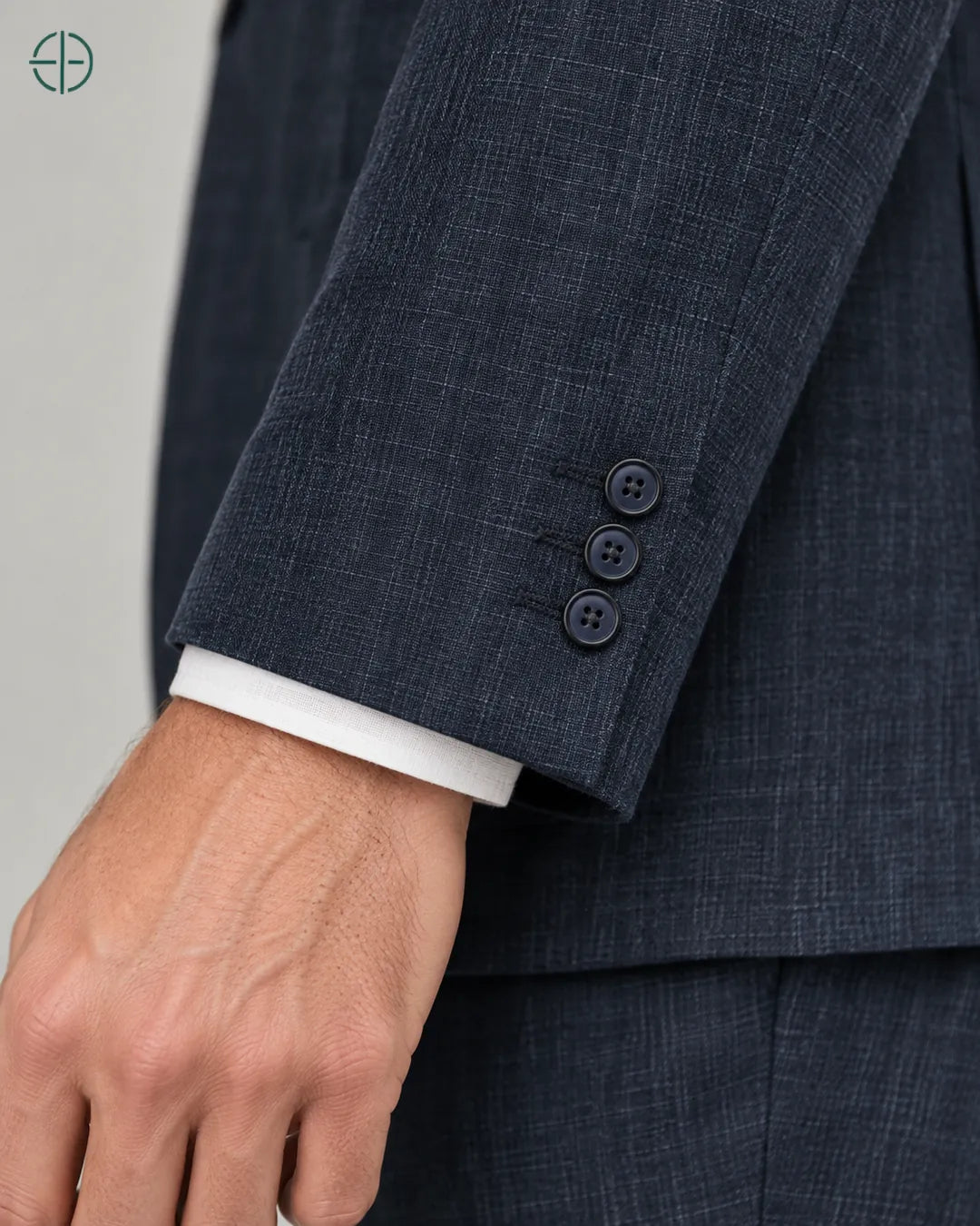 Blazer 100% Linho Belga, cor Azul Marinho, Detalhe aproximado do tecido e da costura no modelo, mostrando textura real, em estúdio profissional com fundo cinza ostra.