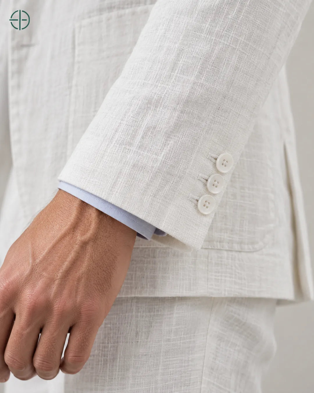 Blazer 100% Linho Belga, cor Branco, Detalhe aproximado do tecido e da costura no modelo, mostrando textura real, em estúdio profissional com fundo cinza ostra.