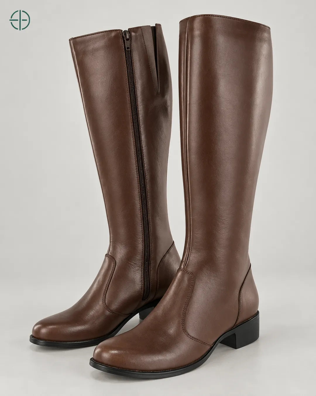 Bota Montaria Couro Legítimo Feminino, variante Castor, aparência marrom médio de fundo acinzentado, Par de botas em três quartos de frente, em estúdio profissional com fundo cinza ostra.
