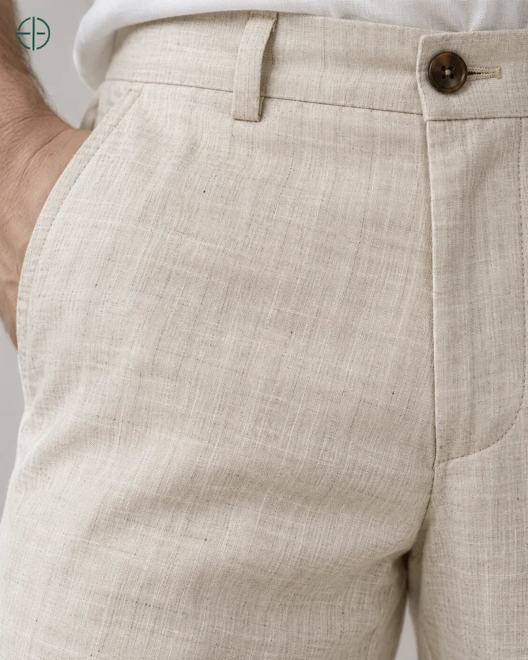 Calça 100% Linho Belga Masculina, cor Bege, macro do produto no modelo, em estúdio profissional com fundo cinza ostra.