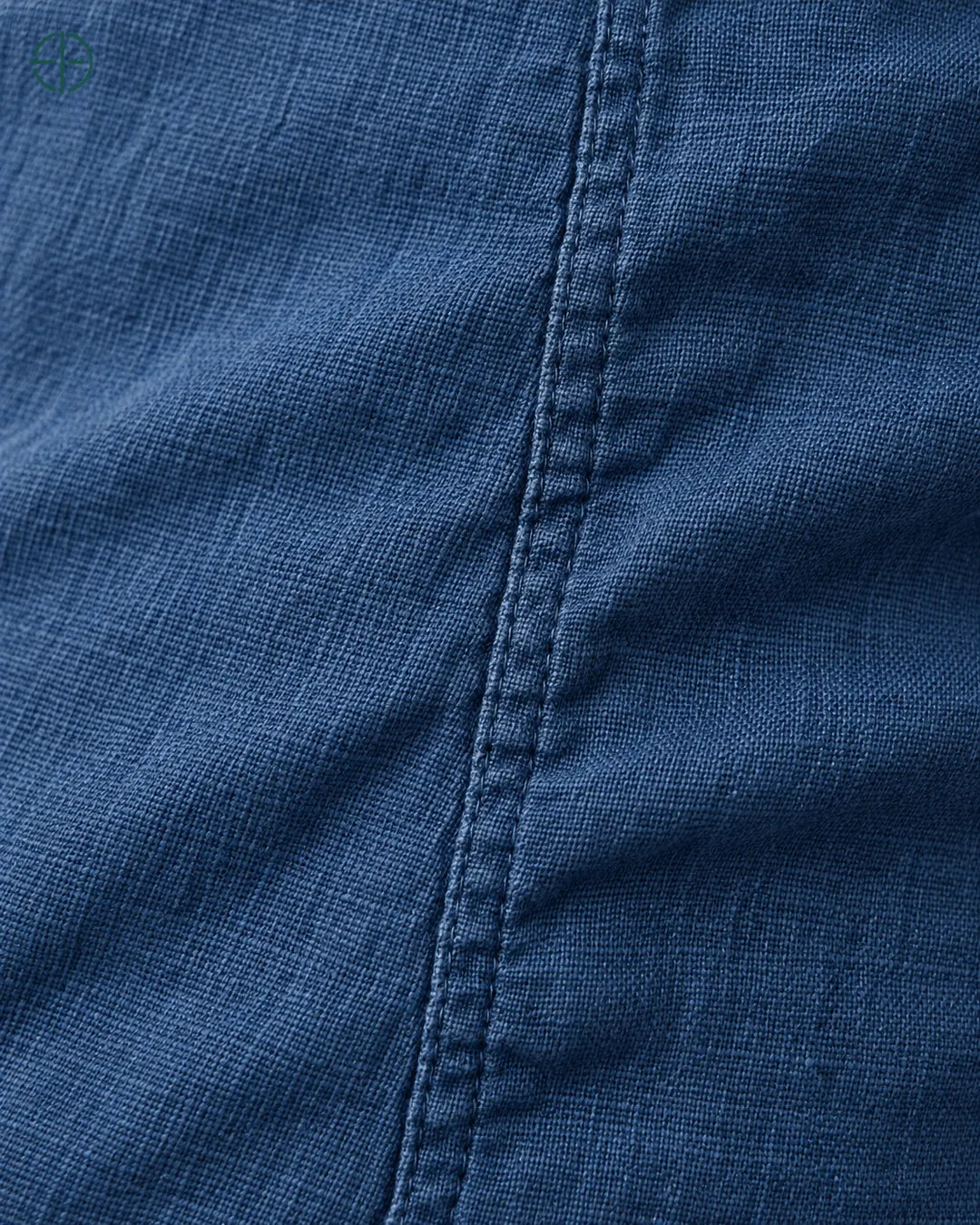 Camisa 100% Linho Belga Manga Curta, cor Azul Marinho, macro do produto no modelo, em estúdio profissional com fundo cinza ostra.
