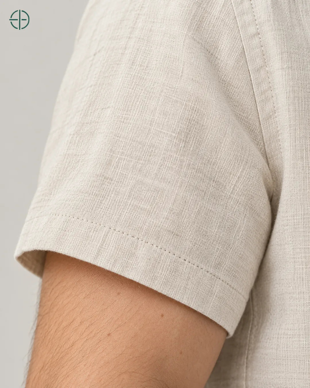 Camisa 100% Linho Belga Manga Curta, cor Bege, detalhe tátil da trama e costura no modelo. Fotografia de produto Rest Money.