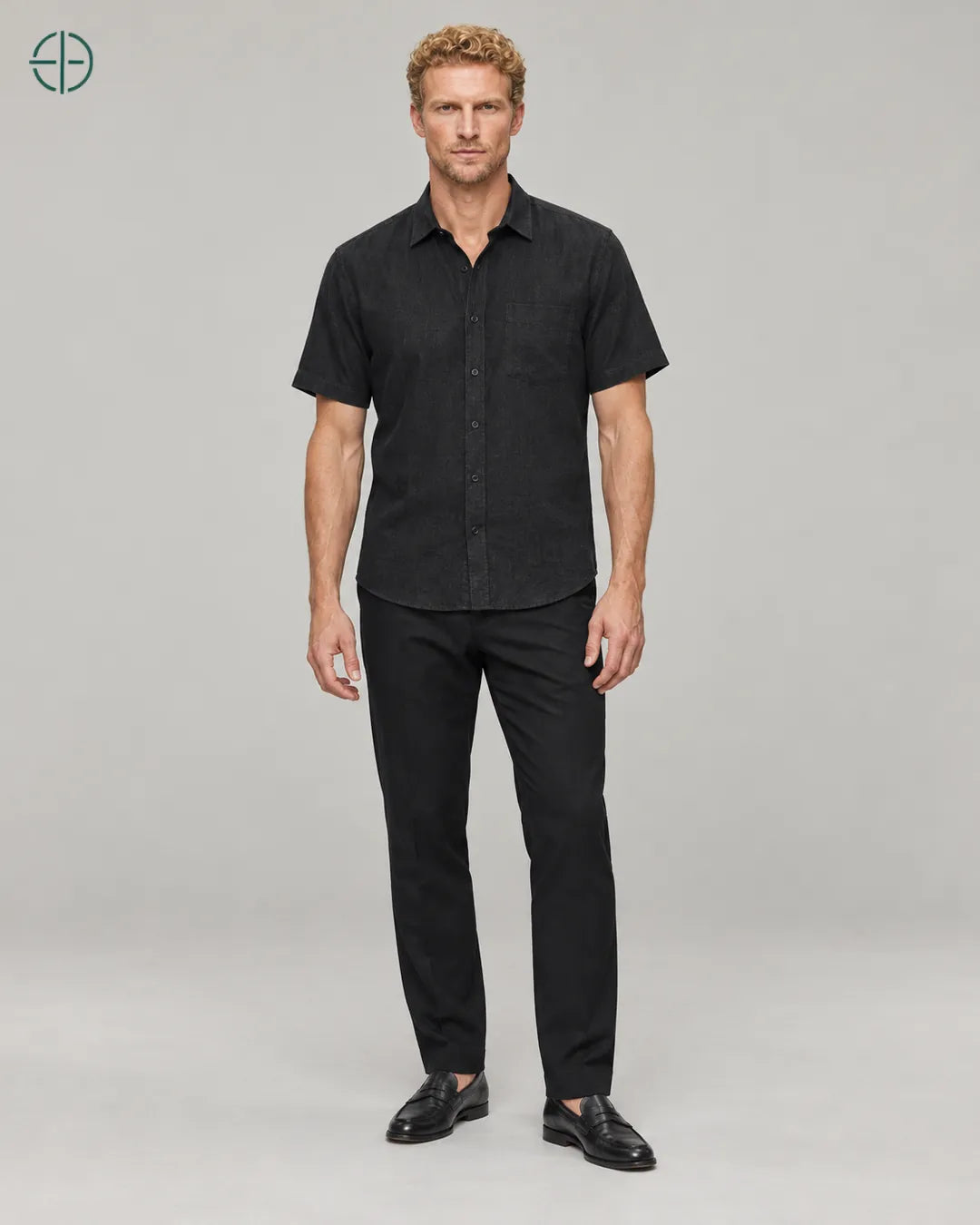 Camisa 100% Linho Belga Manga Curta, cor Preto, modelo usando de frente, em estúdio profissional com fundo cinza ostra.
