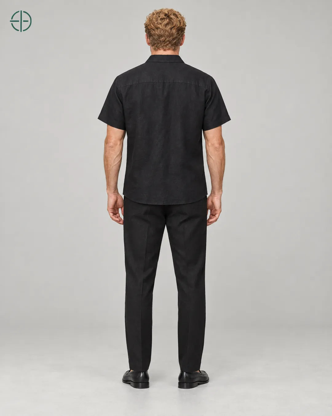 Camisa 100% Linho Belga Manga Curta, cor Preto, mesmo modelo e roupa de costas, em estúdio profissional com fundo cinza ostra.
