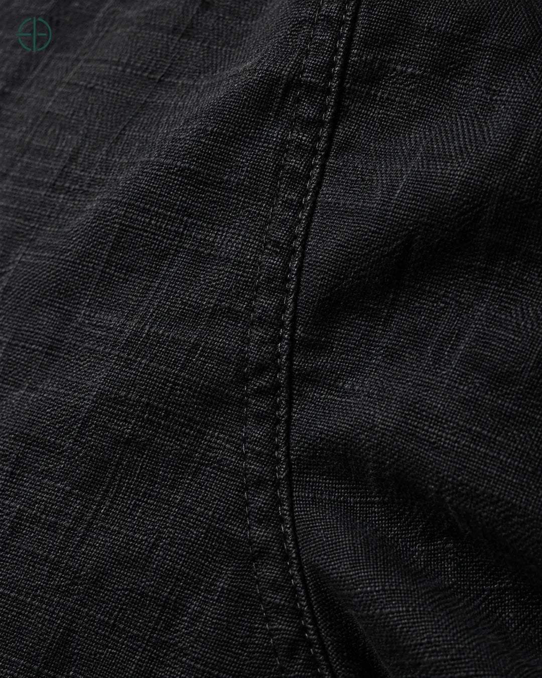 Camisa 100% Linho Belga Manga Curta, cor Preto, macro do produto no modelo, em estúdio profissional com fundo cinza ostra.