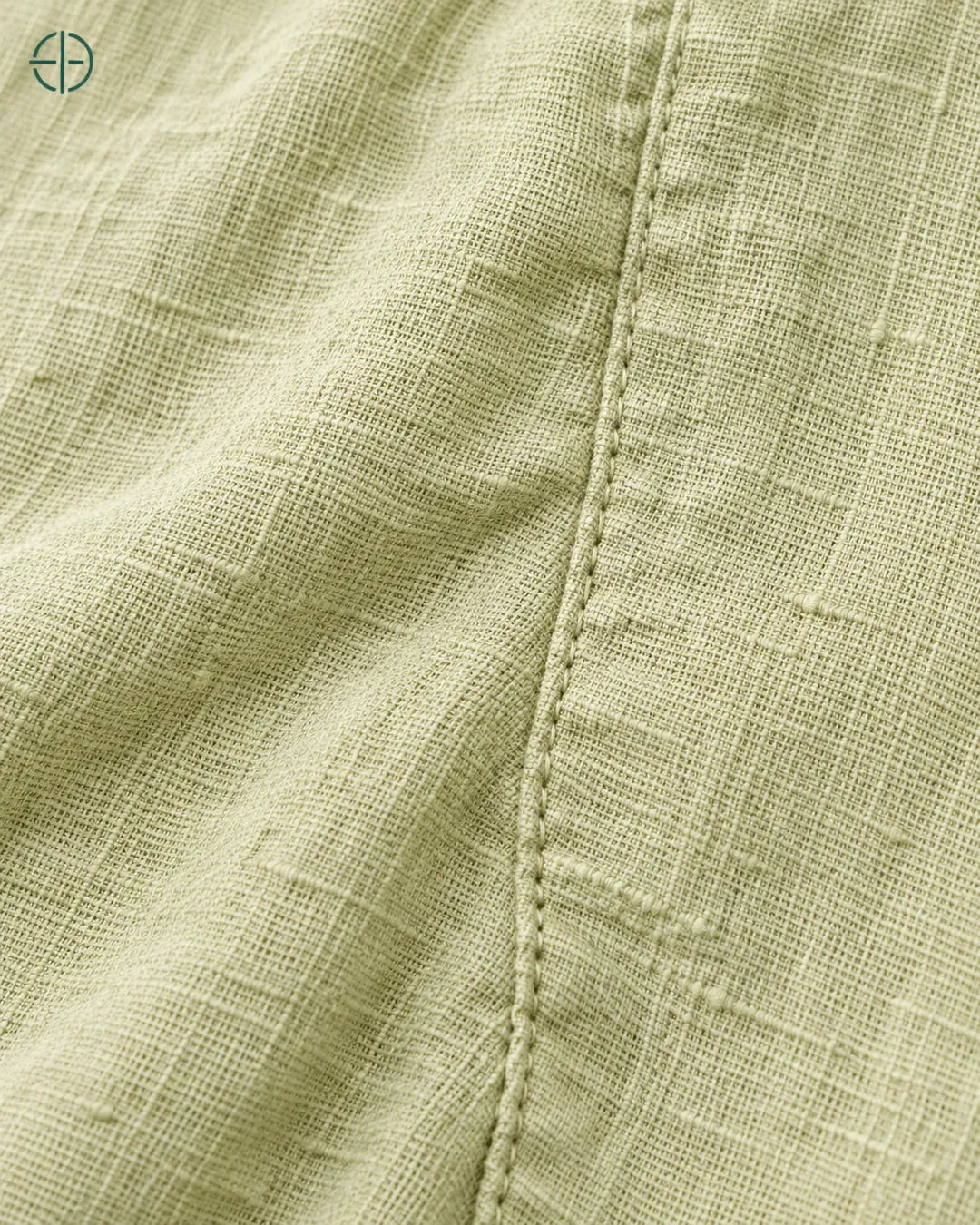 Camisa 100% Linho Belga Manga Curta, cor Verde Limão, macro do produto no modelo, em estúdio profissional com fundo cinza ostra.