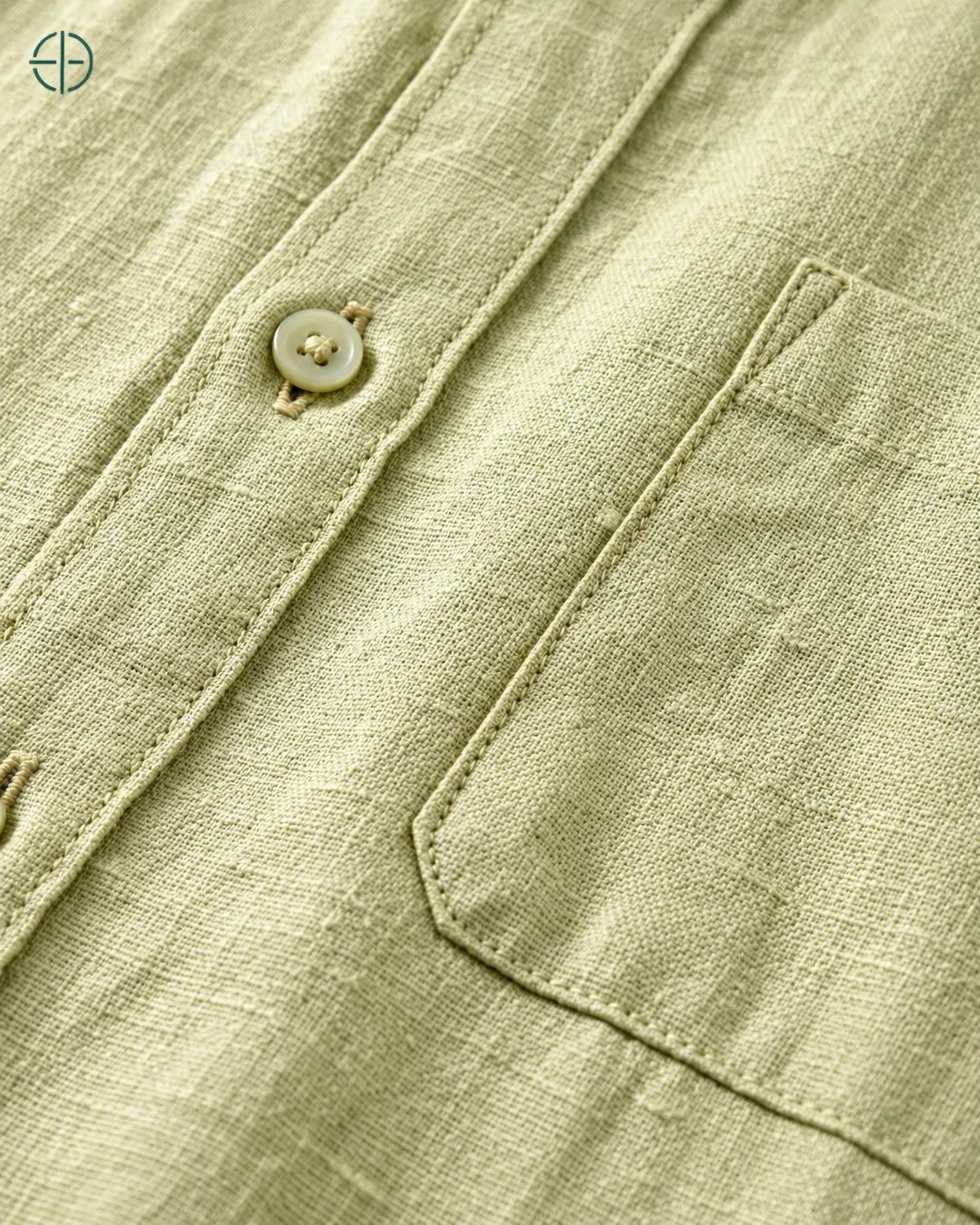 Camisa 100% Linho Belga Manga Curta, cor Verde Limão, Detalhe aproximado do tecido e da costura no modelo, mostrando textura real, em estúdio profissional com fundo cinza ostra.
