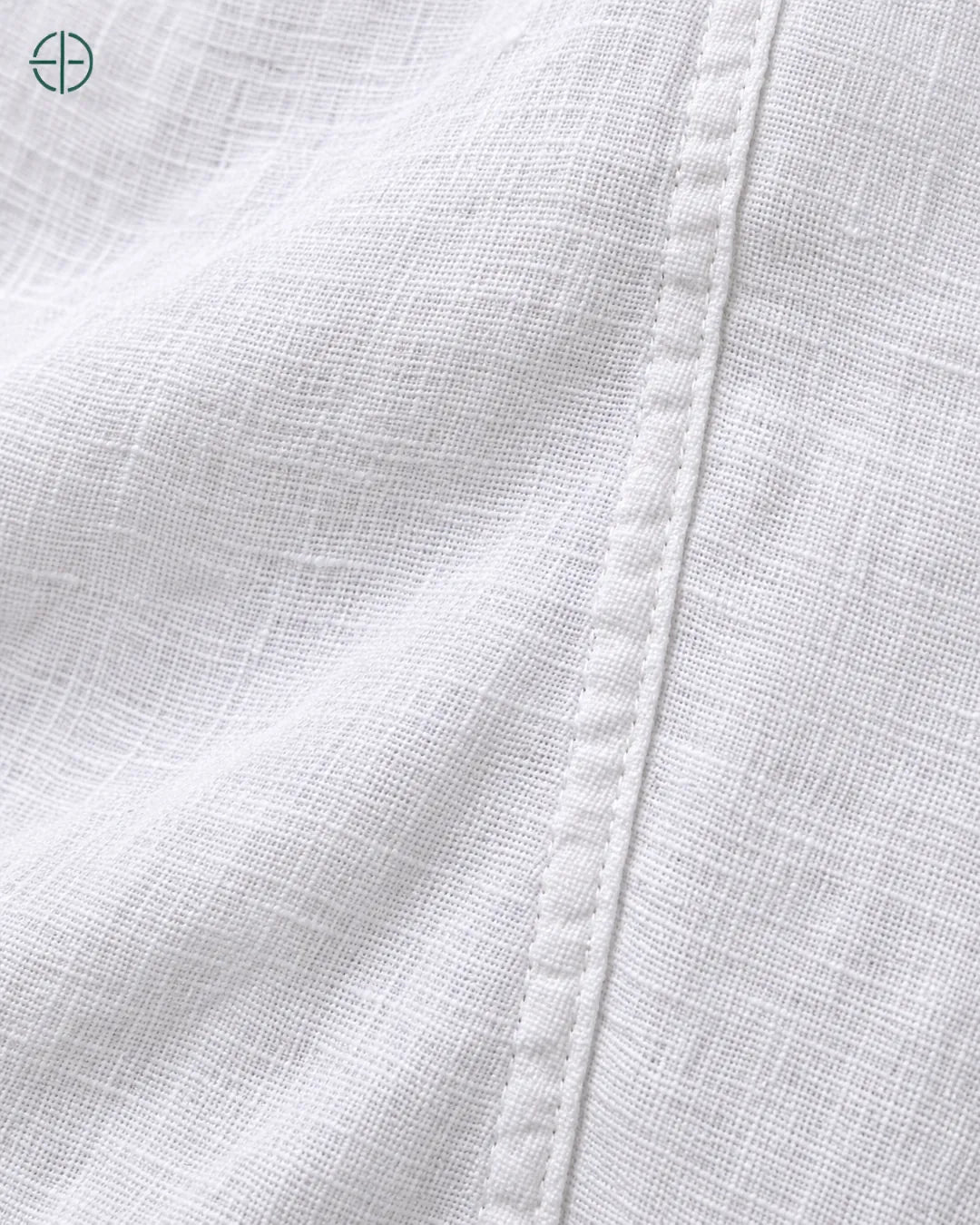 Camisa 100% Linho Belga Masculina, cor Branco, macro do produto no modelo, em estúdio profissional com fundo cinza ostra.