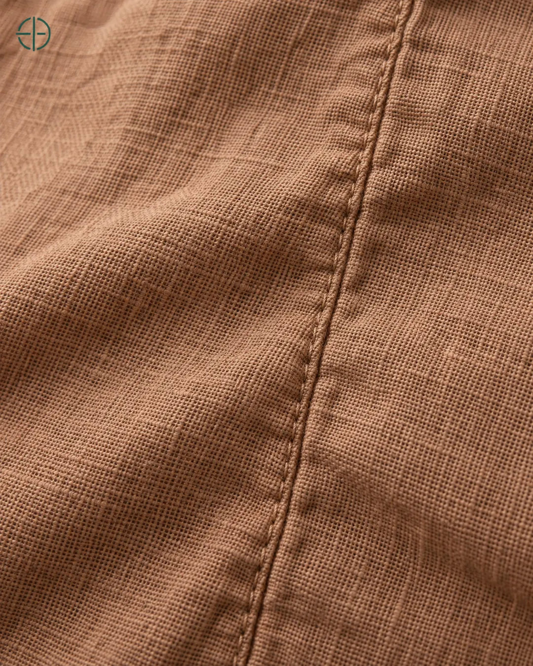 Camisa 100% Linho Belga Masculina, cor Bronze, macro do produto no modelo, em estúdio profissional com fundo cinza ostra.